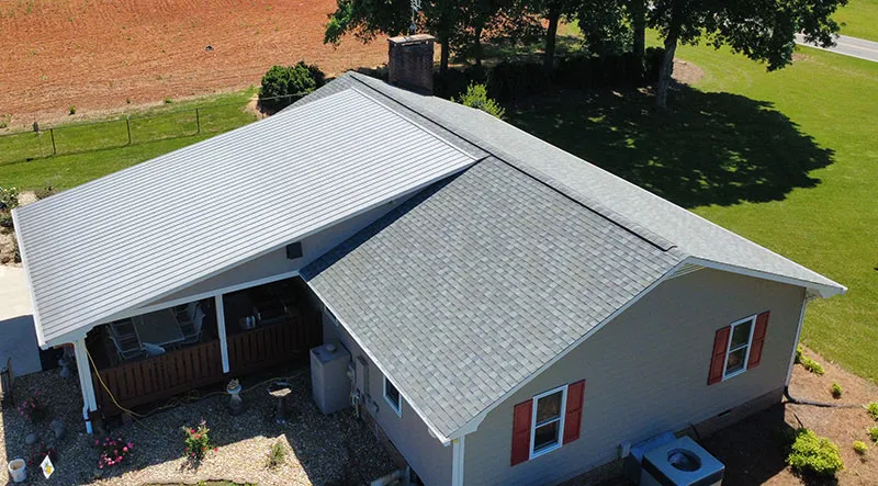 Gray shingles on a roof beside an adjacent metal porch roof.
