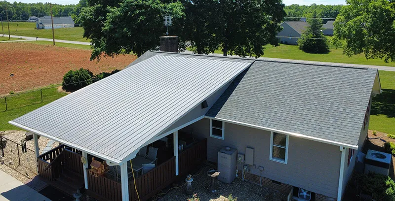 Gray shingles beside an adjoining metal-roofed porch.