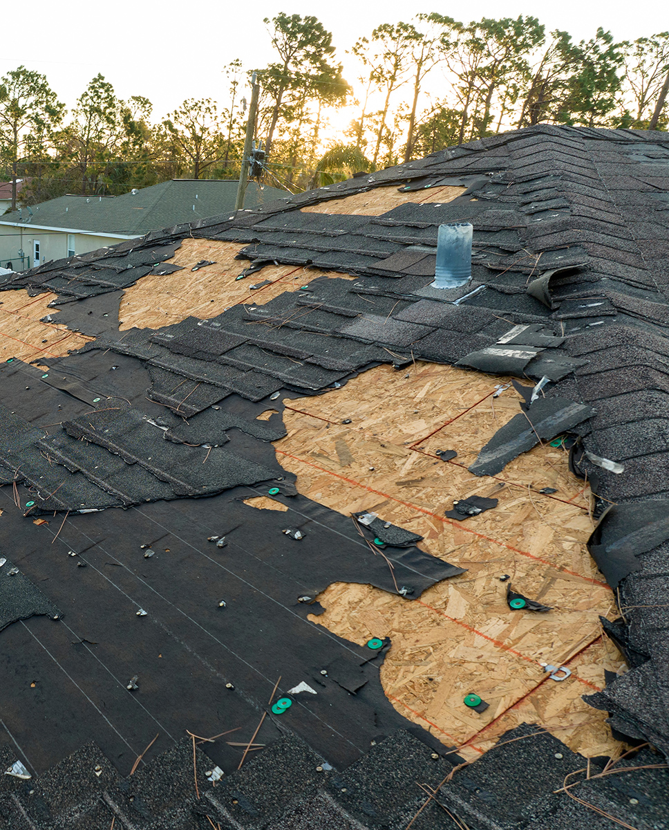 Aerial view of a damaged roof with missing shingles.