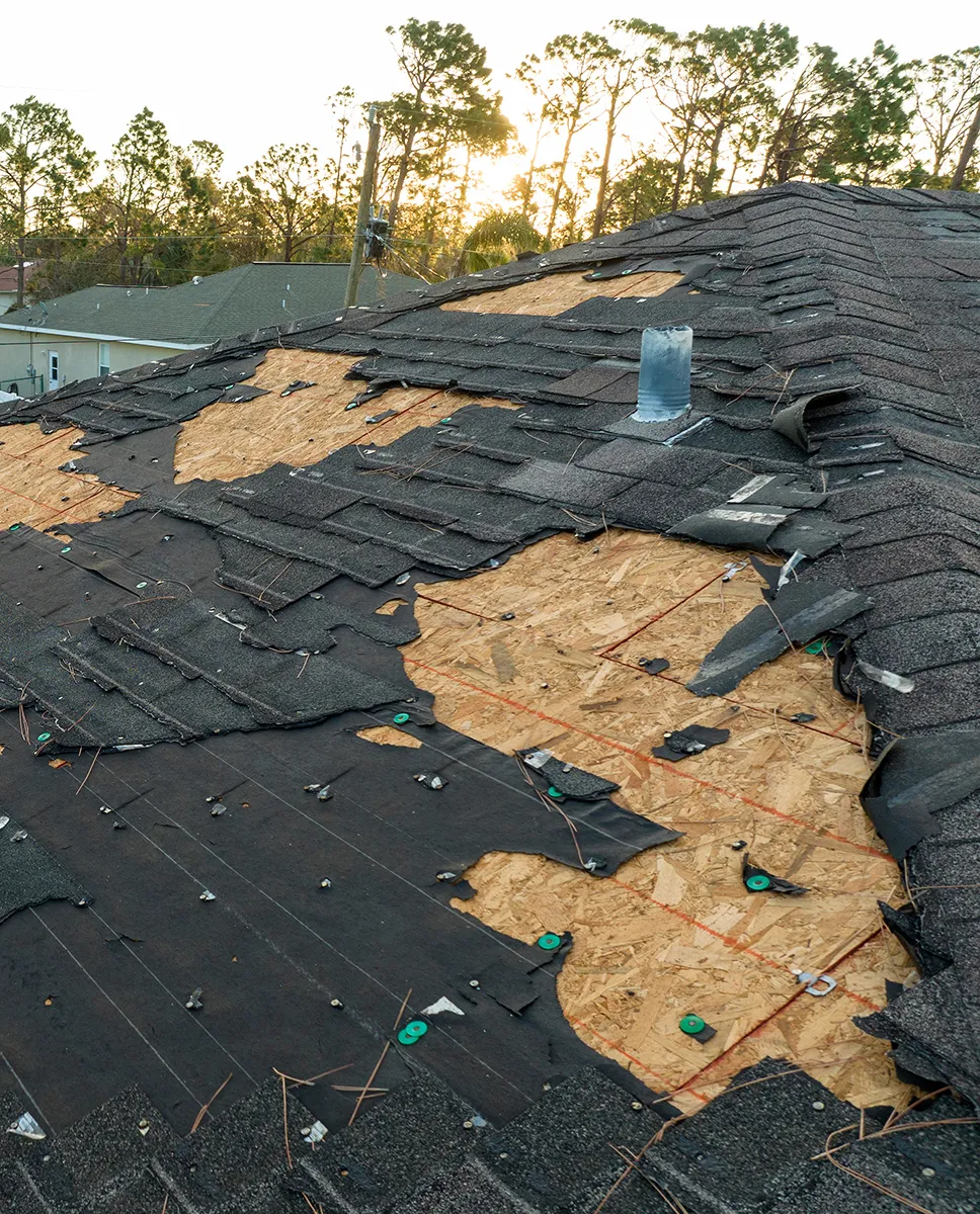 Aerial view of a damaged roof with missing shingles.